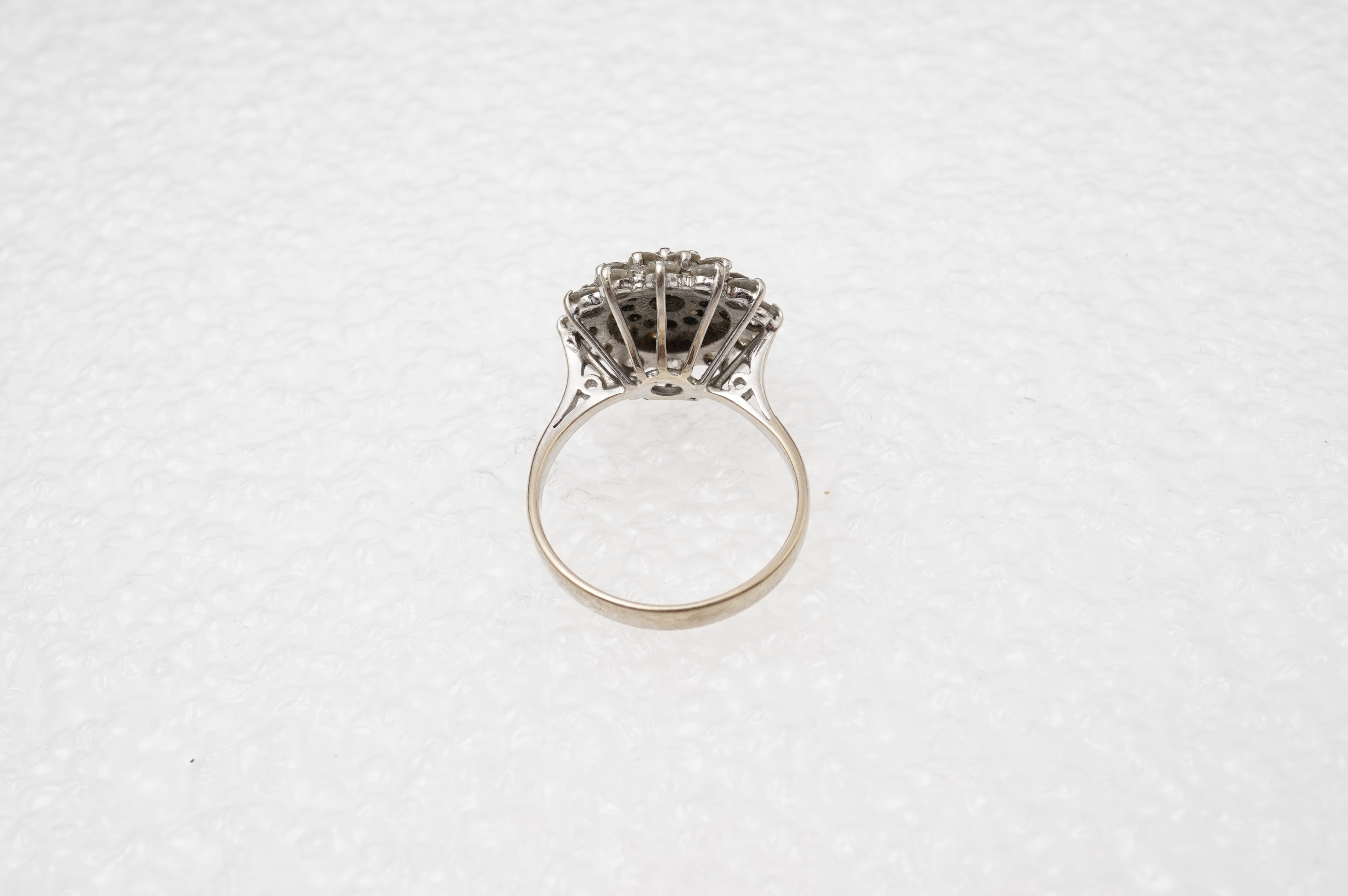 A white gold and diamond cluster ring, set with a concentric arrangement of brilliant-cut diamonds totalling approximately 1.50 carats, size M, gross weight approximately 5 grams